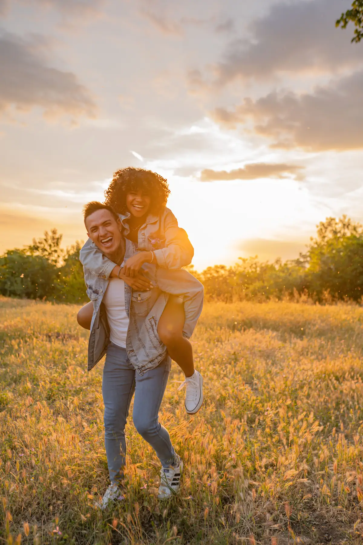 Illustrative stock photo of a couple in a field at golden hour, not real members